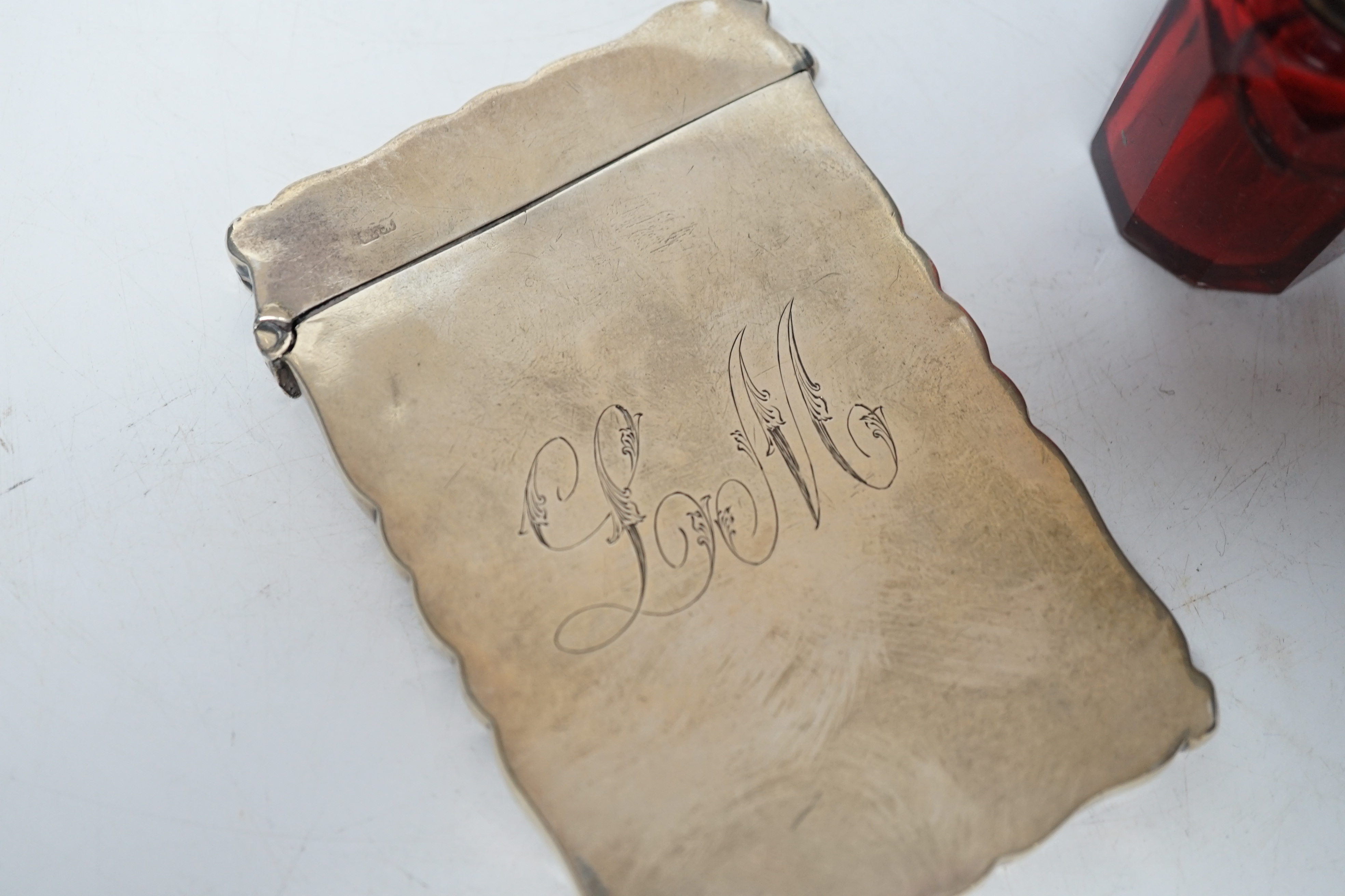 A late Victorian silver mounted ruby glass scent bottle, Birmingham, 1897, 61mm and a later silver card case (a.f.).